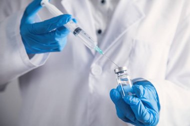 Doktor şırıngayı dolduruyor. Aşılama kavramı