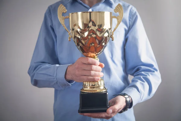 Businessman holding golden trophy. Business, Success