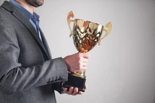 Businessman holding golden trophy. Business, Success