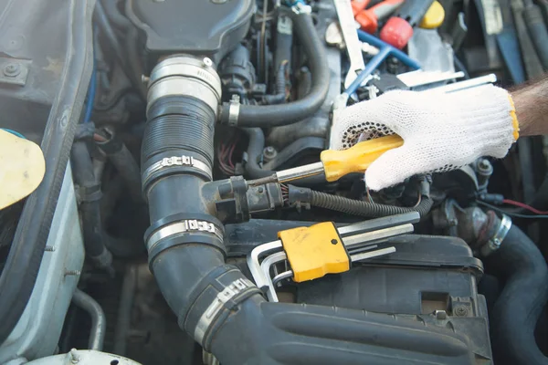 Mecánico sosteniendo destornillador amarillo. Reparación de automóviles, Centro de servicio — Foto de Stock