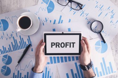 Masada finansal grafikleri olan bir adam. Kar