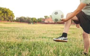 Futbol sahasında futbol topu olan beyaz bir çocuk..