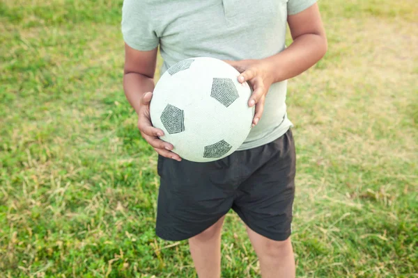 Ragazzo caucasico con un pallone da calcio su un campo di calcio. — Foto Stock