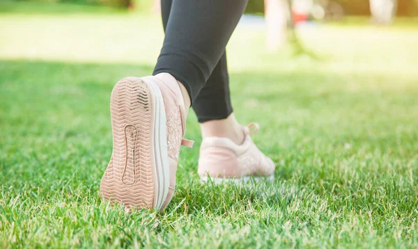 Yaz parkında çim üzerinde koşu ayakkabıları kız. — Stok fotoğraf