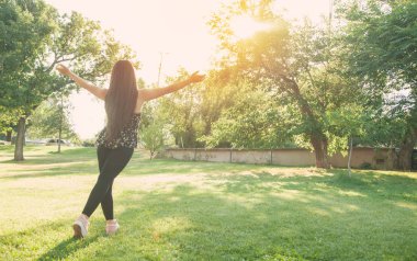 Parkta elini kaldıran güzel bir kadın. Özgürlük