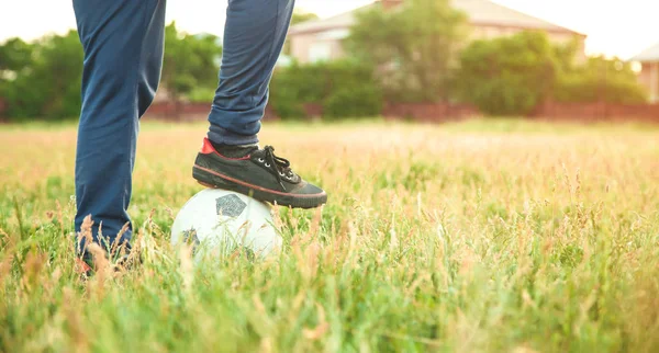 Garçon caucasien avec un ballon de football sur un terrain de football. — Photo