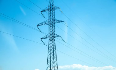 Mavi gökyüzünde elektrik hattı var. Yüksek voltaj kuleleri