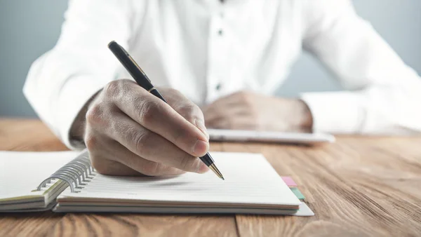 Επιχειρηματίας που γράφει σε ένα σημειωματάριο στο επιχειρηματικό γραφείο. — Φωτογραφία Αρχείου