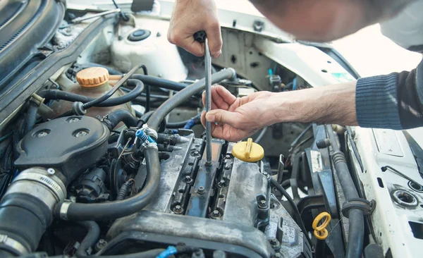 Araba motorunda çalışan tamirci. Oto tamir, Servis merkezi