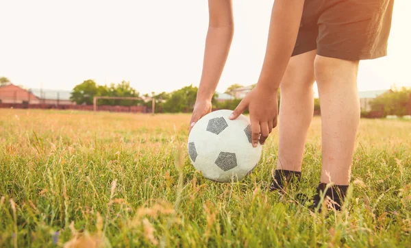 Caucásico chico con una pelota de fútbol en un campo de fútbol. —  Fotos de Stock