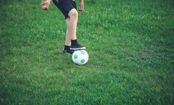 Garçon avec un ballon de football sur un terrain de football . — Photo