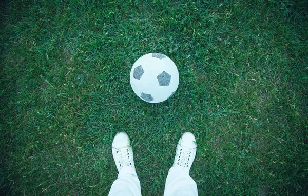 Garçon avec un ballon de football sur un terrain de football . — Photo
