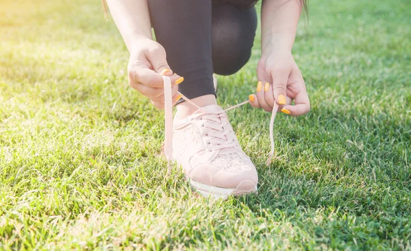 Sporty woman tying laces of running shoes before training outdoo — Stock Photo, Image