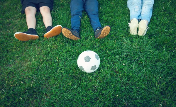 Caucasiens garçons avec un ballon de football sur un terrain de football . — Photo