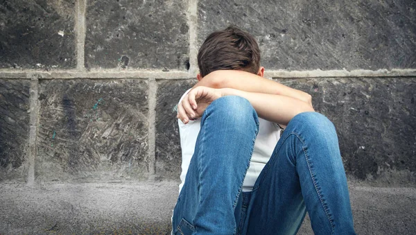 Caucásico triste chico sentado en la calle . — Foto de Stock