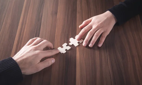 Mãos segurando a peça de quebra-cabeça. Solução, Sucesso, Trabalho em equipe — Fotografia de Stock