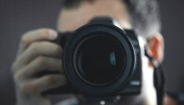 Profesyonel fotoğrafçı bir Dslr kamera tutarak.