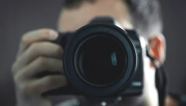 Fotógrafo profesional sosteniendo una cámara DSLR . — Foto de Stock