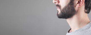 Gri arka planda beyaz sakallı bir adam..