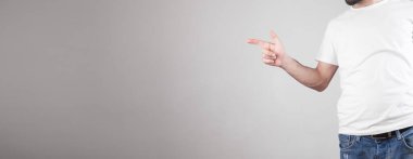 Gri arkaplanı işaret eden adam.