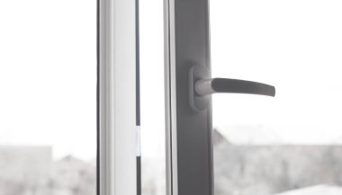 Kapı kolu ile açılan beyaz pencere.