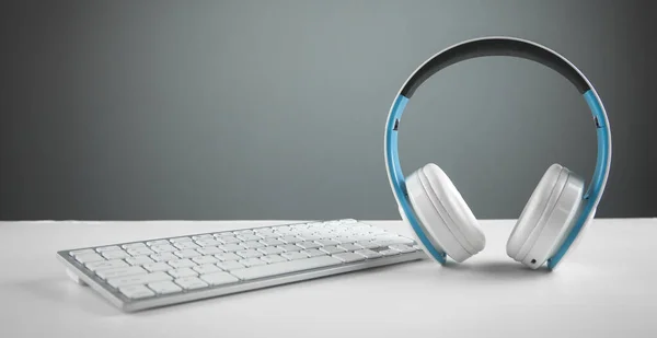 White headphones with a computer keyboard. Business desk