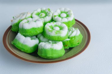 Hindistancevizi rendelenmiş geleneksel Endonezya usulü Putu Ayu pastasına yakın çekim. Tabakta yeşil ve beyaz tatlı ve yemek fotoğrafçılığı ve mutfak konsepti için ahşap tahta..