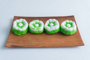Hindistancevizi rendelenmiş geleneksel Endonezya usulü Putu Ayu pastasına yakın çekim. Tabakta yeşil ve beyaz tatlı ve yemek fotoğrafçılığı ve mutfak konsepti için ahşap tahta..