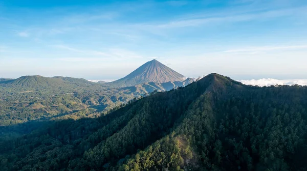 Gün batımında arka planda Inerie Dağı 'nın olduğu, sergilenen katmanlı manzaralar, doğal güzellik ve sıcak akşam ışığı ile birlikte ormanlık tepelerin baş aşağı muhteşem manzarası..