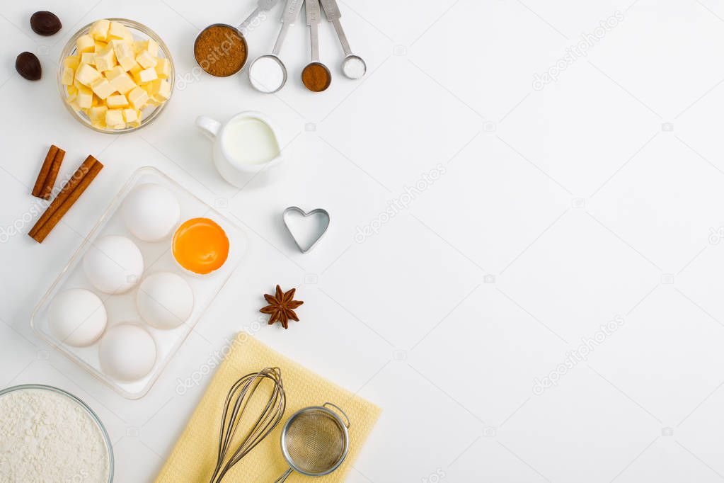 Cooking baking flat lay background with eggs yolk a cup of butter flour milk spices cinnamon anise
