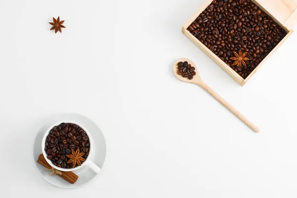 Cup of coffee seeds, cinnamon, anis, wooden box and spoon with coffee on white background. I love coffee, coffee lover concept. Horizontal orientation, place for copy space.