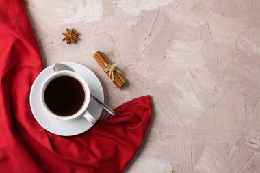 Beyaz fincan kahve ya da çay, kırmızı peçete, baharat tarçın, anason bej beton zemin üzerine. Yatay yönlendirme, üstten görünüm, düz yatıyordu, kopya alanı, metin için yer.