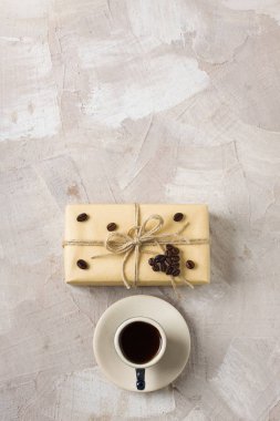 Kahve fincanı, zanaat hediye kutusu, sicim, kahve kalp şekli dekorasyon bej beton zemin üzerine mavi. Kahve severler için bir hediye dekor fikri. Dikey yönlendirme üstten görünüm düz yatıyordu yer alan metin Kopyala.