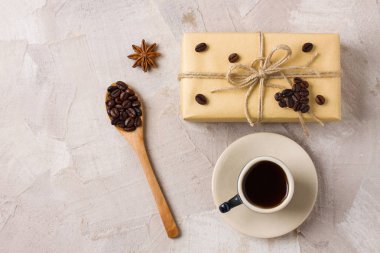 Mavi kahve fincanı, zanaat hediye kutusu sicim kahve kalp şekli dekorasyon, tahta kaşıkla kahve çekirdekleri, anason bej beton zemin üzerine. Kahve severler için bir hediye dekor fikri. Kopya alanı metin için yer.