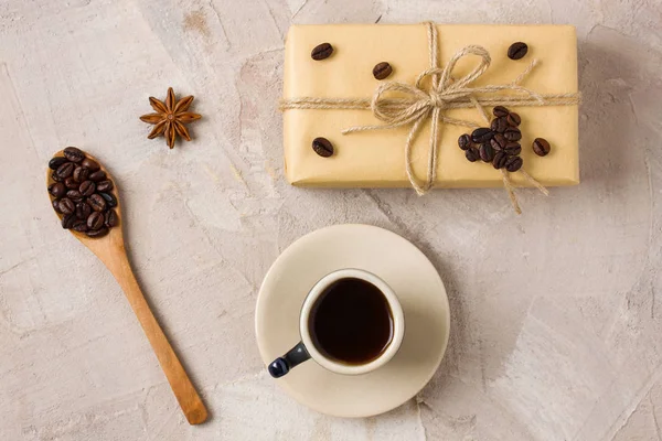 青いコーヒー カップ コーヒー デコレーション コーヒー豆の木のスプーン ベージュの具体的背景にアニスにクラフト ギフト ボックスが麻ひも コーヒー恋人のためのギフトの装飾の考え 平面図 — ストック写真