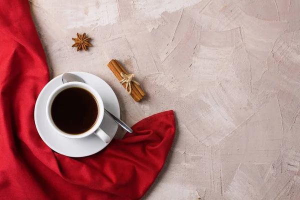 Beyaz fincan kahve ya da çay, kırmızı peçete, baharat tarçın, anason bej beton zemin üzerine. Yatay yönlendirme, üstten görünüm, düz yatıyordu, kopya alanı, metin için yer.