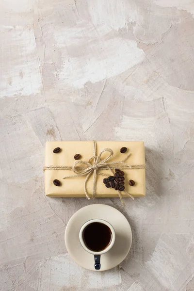 Kahve fincanı, zanaat hediye kutusu, sicim, kahve kalp şekli dekorasyon bej beton zemin üzerine mavi. Kahve severler için bir hediye dekor fikri. Dikey yönlendirme üstten görünüm düz yatıyordu yer alan metin Kopyala.