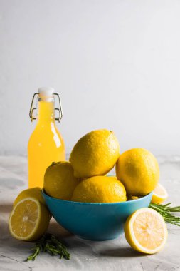 Taze dilimlenmiş limon biberiye şişe limon İçecek suyu ev yapımı limoncello ile mavi tabak