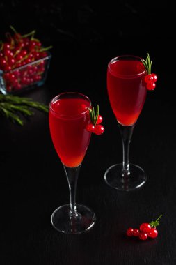 Somun şarap içecek suyu iki bardak biberiye ve çilek, somun meyveleri koyu ahşap zemin üzerine bir fincan ile dekore edilmiştir. Dikey yönlendirme.