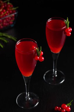 Somun şarap içecek suyu iki bardak biberiye ve çilek, somun meyveleri koyu ahşap zemin üzerine bir fincan ile dekore edilmiştir. Dikey yönlendirme.