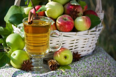 Beyaz hasır sepet ile yeşil ve kırmızı elma, elma suyu, meyve suyu ya da sirke cam, Doğa arka planda, güneş ışığı bırakır. Yaz, sonbahar, taze elma hasat, hasat.