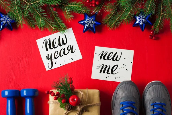 Noel spor düz kompozisyon mavi dumbbells spor ayakkabı hediye kutusu Ladin ağaç dalları yeni yıl yeni bana kırmızı ahşap arka plan yazı yatıyordu. Kavram yeni yıl sağlıklı yaşam ve spor için özel.