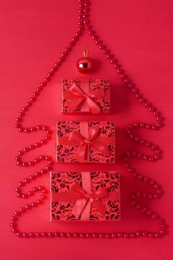 Noel ağacı kompozisyon boncuk hediye kutuları top kırmızı ahşap arka planını yaptım. Yeni yıl merry xmas kış tatil tebrik kartı. Üstten görünüm minimalizm tarzı tek renkli düz yatıyordu.