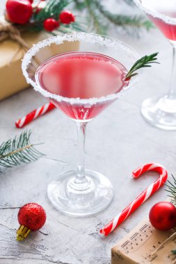 Biberiye ve şeker dekorasyon, çam ağaçları, topları, baston şekerler ile martini içki ile Noel kompozisyon, zanaat hediye kutu kırmızı renkler, gri beton arka planda. Kış tatili, yeni yıl partisi konsepti.