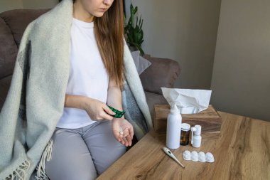 Hasta genç kadın su toplayıcıdan tablet hapı, grip ilacı, yüksek ateş ve viral enfeksiyon tedavisi, evde sağlık ve iyileşme tedavisi alıyor..