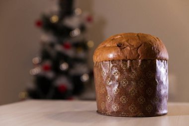 Panettone with blurry Christmas lights blinking in the background. Panettone concept. Christmas concept.	