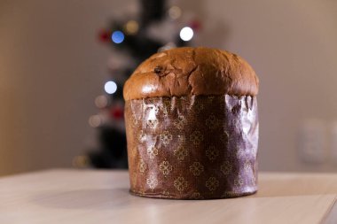 Panettone with blurry Christmas lights blinking in the background. Panettone concept. Christmas concept.	