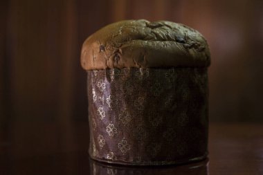 Panettone on the wooden table with textured brown woody background. Panettone concept. Space for text. Christmas concept.	