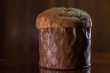 Panettone on the wooden table with textured brown woody background. Panettone concept. Space for text. Christmas concept.	