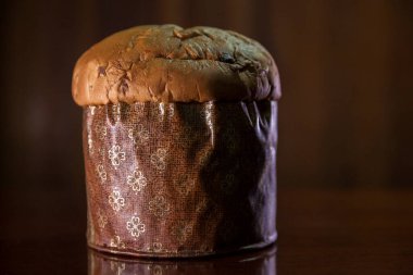 Panettone on the wooden table with textured brown woody background. Panettone concept. Space for text. Christmas concept.	